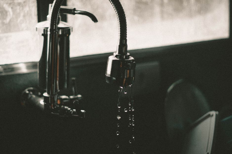 Close-up of a plumber inspecting drainage pipes in a home bathroom in Fareham